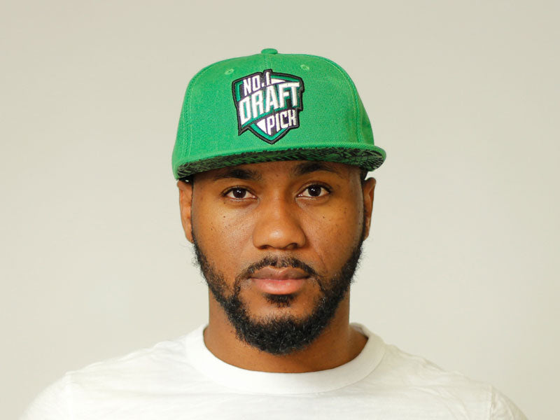 Green Boston cap with embroidered lettering, curved brim, and adjustable strap for unisex streetwear and sports style